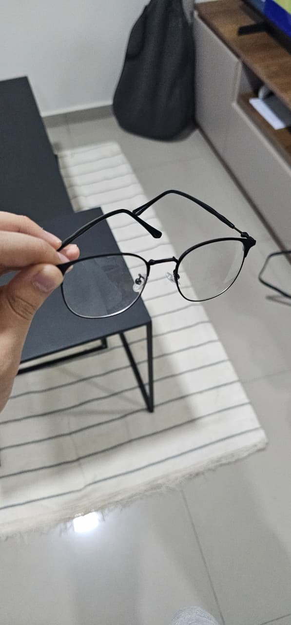 Anteojos Optiqq sostenidos en una sala